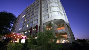 A multi-story hotel with a curved entrance and a large sign. - Mercure Sydney Parramatta (Rosehill)