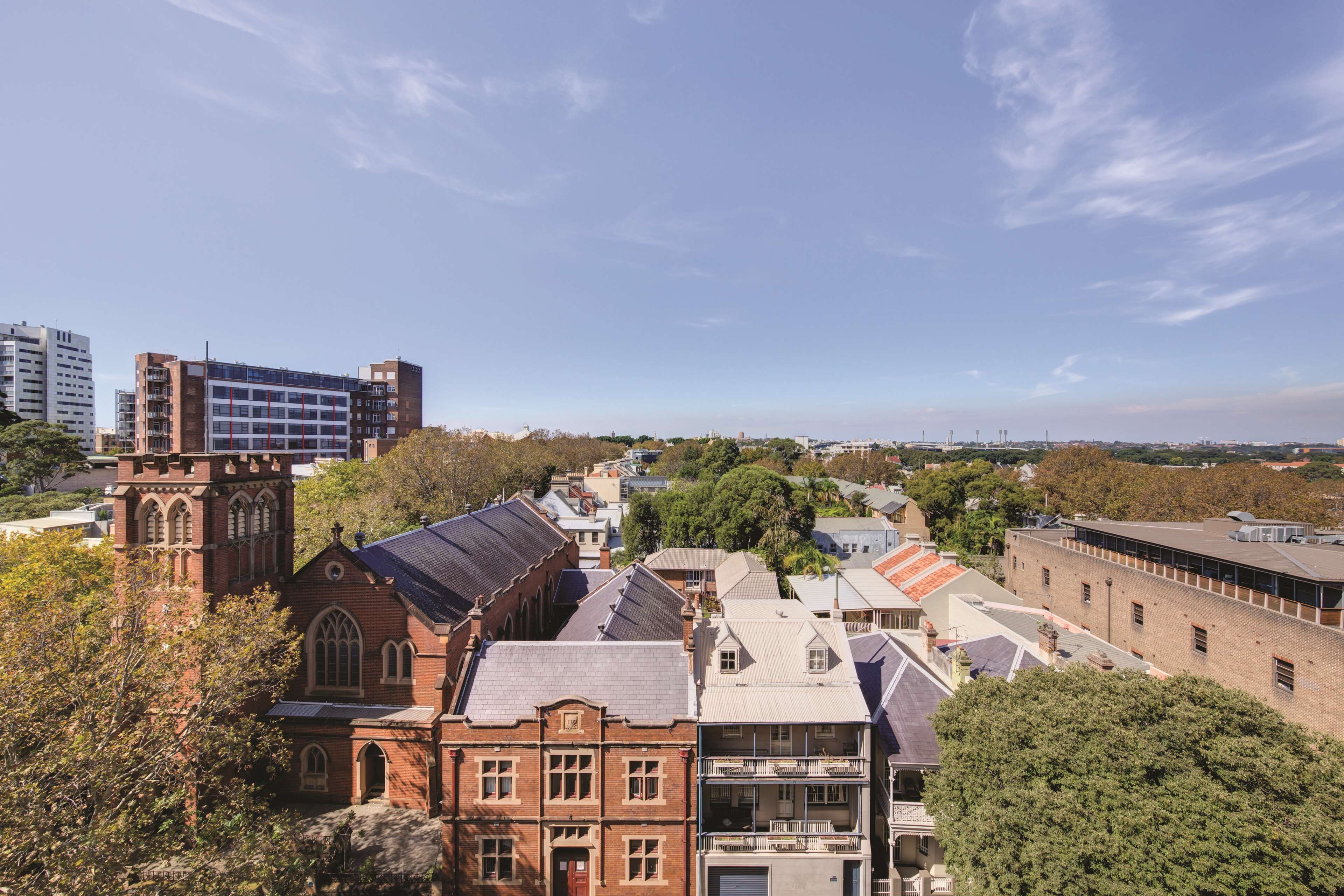 A historic building with a prominent tower and adjacent residential buildings.