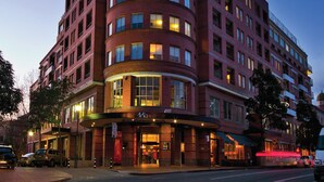 Un hotel de varios pisos con un llamativo letrero circular en la parte superior.