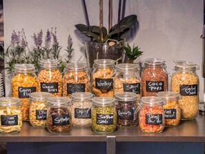 Fresh fruit and nuts are neatly arranged on a shelf, complemented by a potted plant.