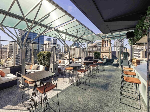 A rooftop bar with outdoor seating, a city view, and a modern architectural design. - Mercure Brisbane King George Square (Brisbane)