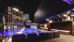 An outdoor pool area with lounge seating and a bar. - Mercure Brisbane King George Square (Brisbane)