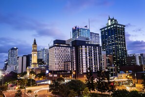 Experience the vibrant city atmosphere with a stunning clock tower and sleek high-rise buildings.