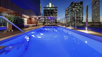 Una piscina al aire libre, sillones reclinables de piscina
