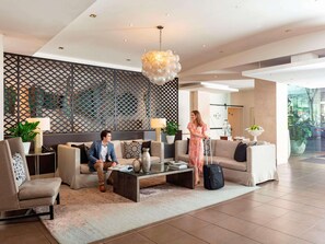 A modern lobby with a seating area, a decorative wall, and a view of the outdoors.