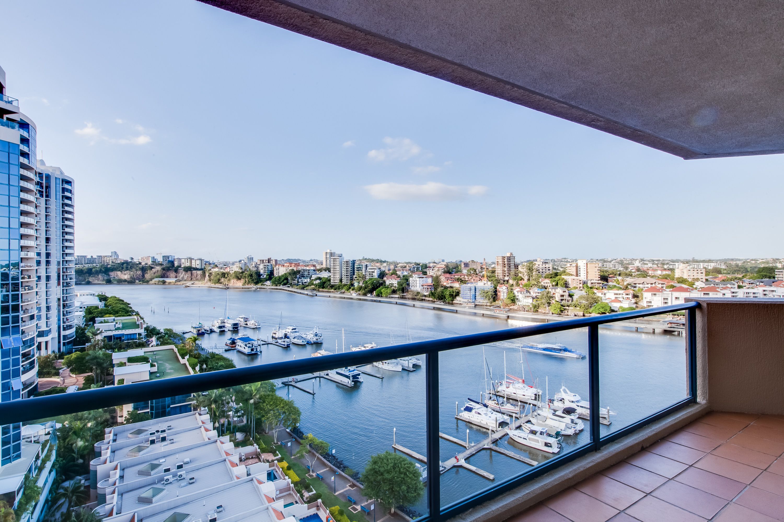 A balcony with a view of a marina, cityscape, and buildings.