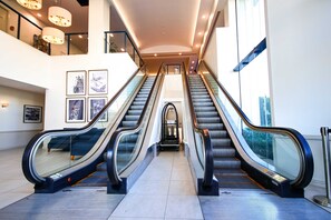 An indoor escalator area with glass railings and a tiled floor. - Dockside Brisbane (Kangaroo Point)