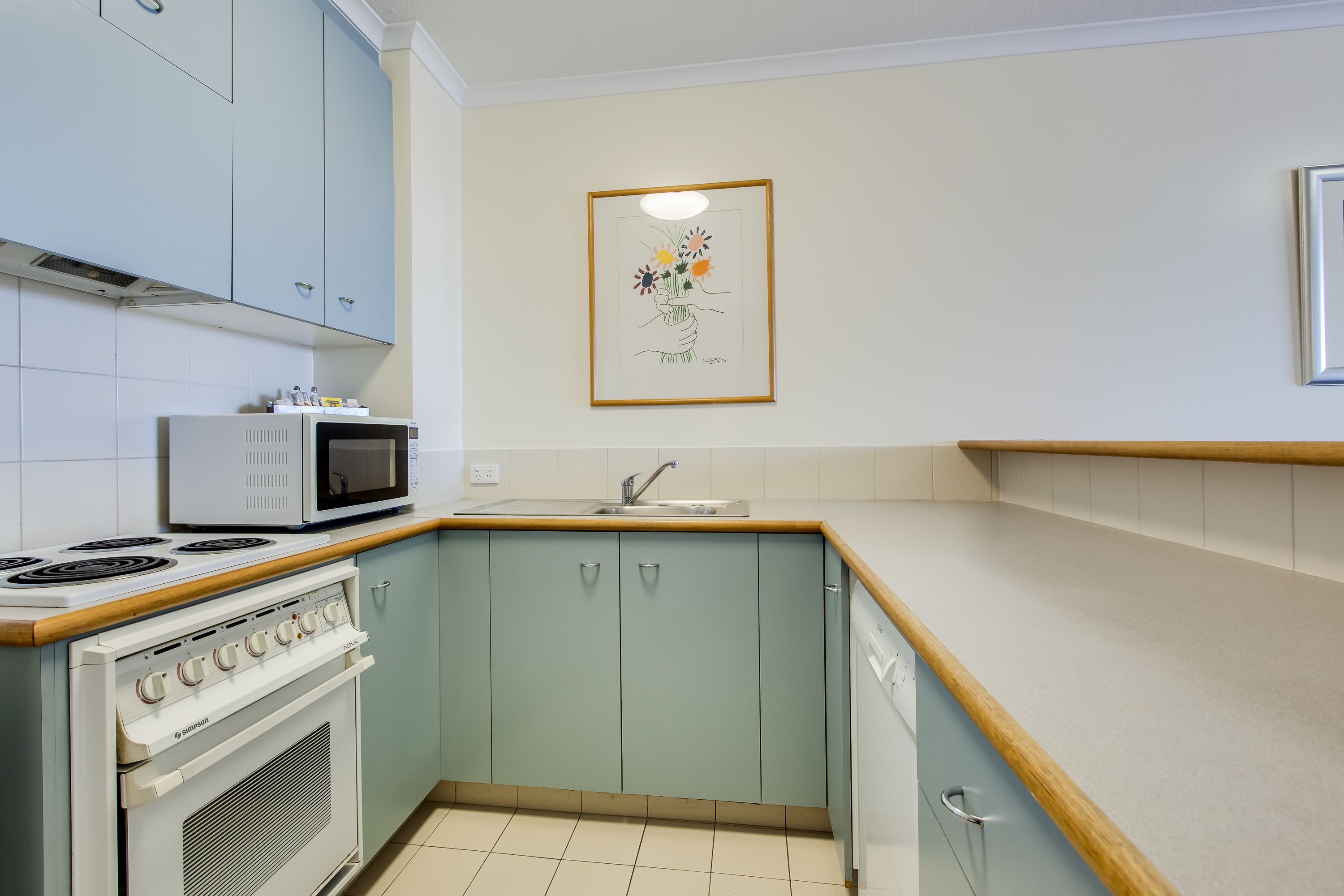 A compact kitchen with a built-in microwave, stove, and oven.