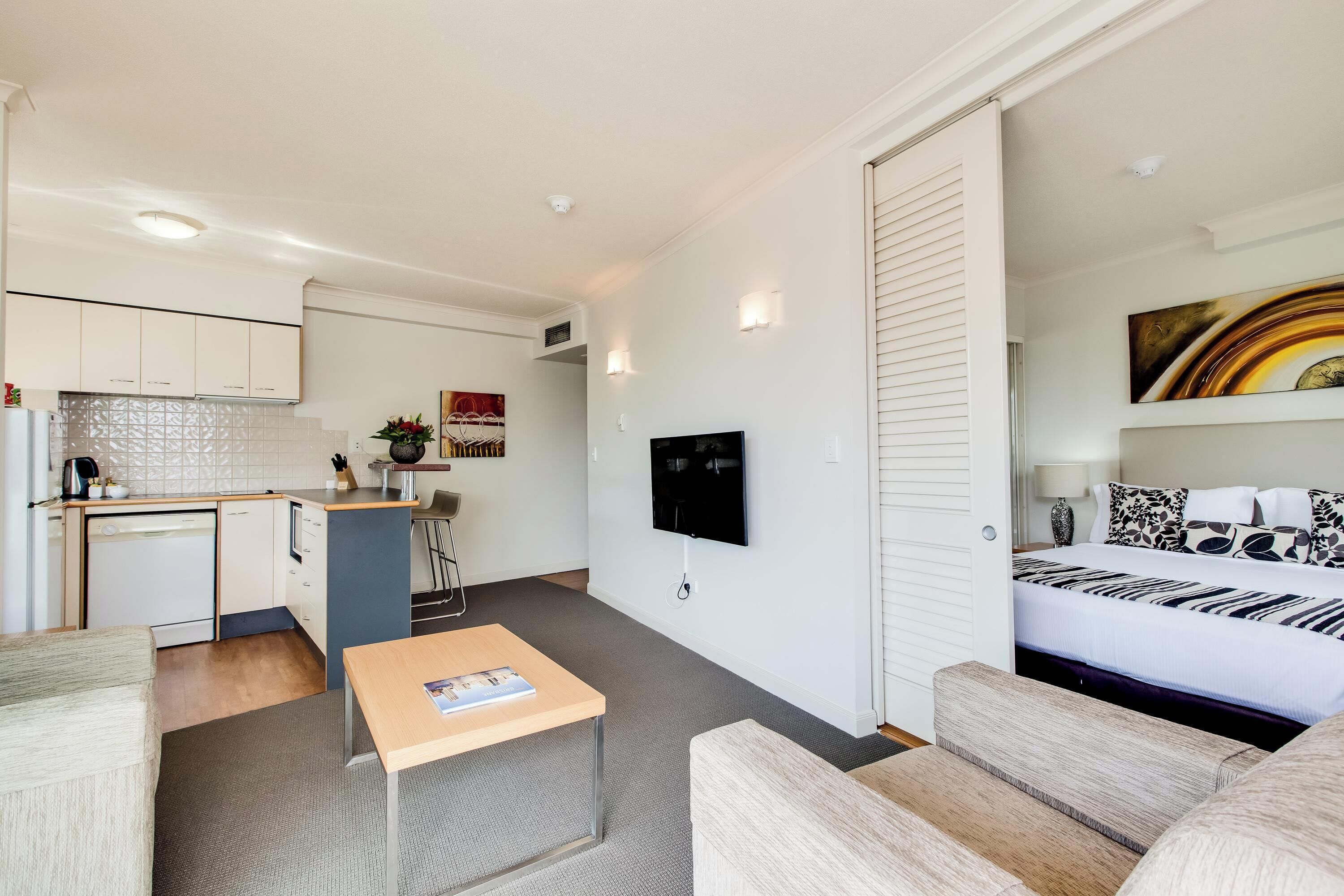 A modern apartment with a kitchenette, a dining area, and a living room.