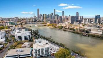 A cityscape with modern buildings, a river, and a bridge.