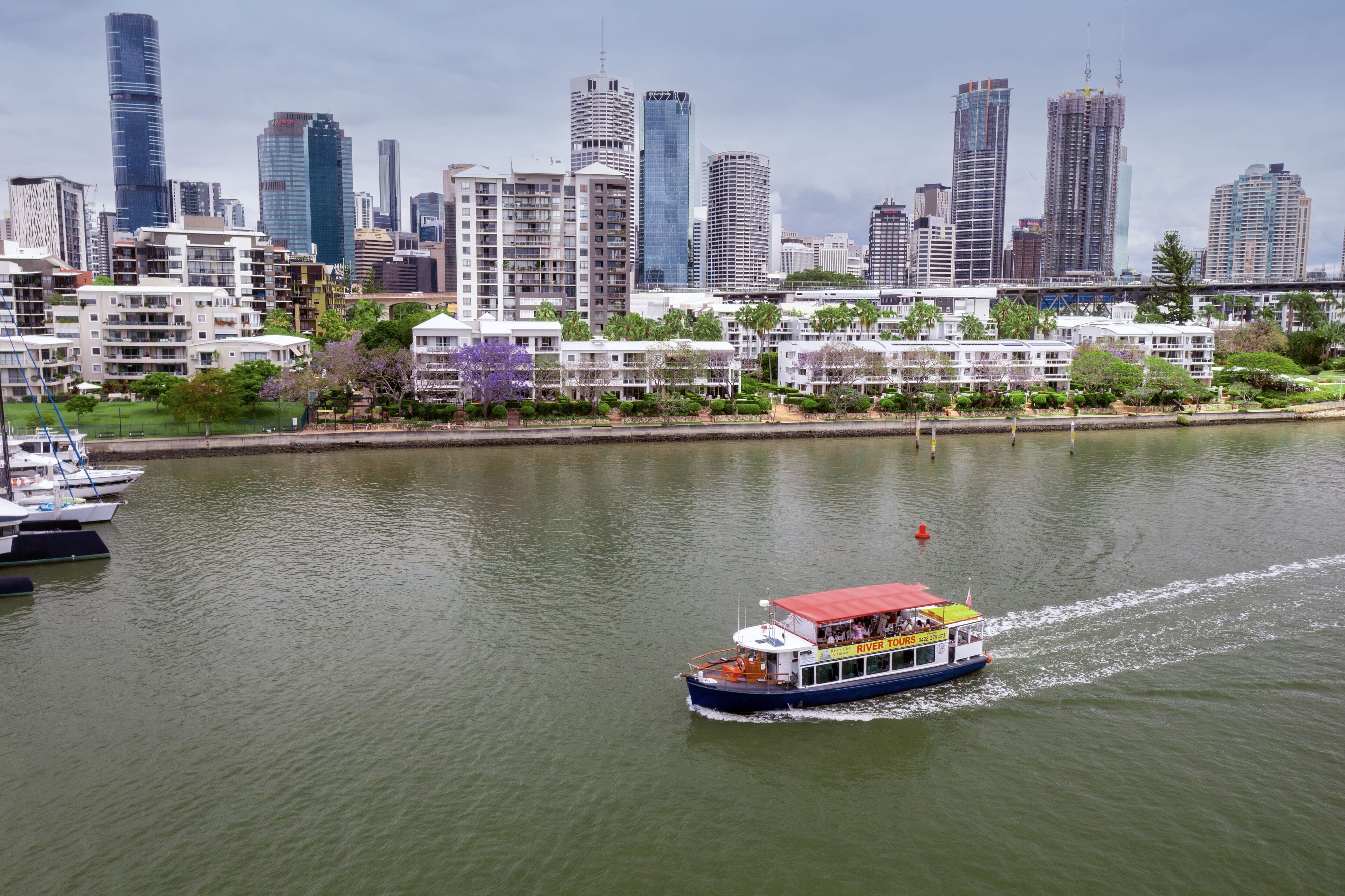 Ein Fluss mit einem Boot und einer Stadtansicht im Hintergrund.