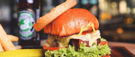 Una hamburguesa con papas fritas y una botella de cerveza en una bandeja.