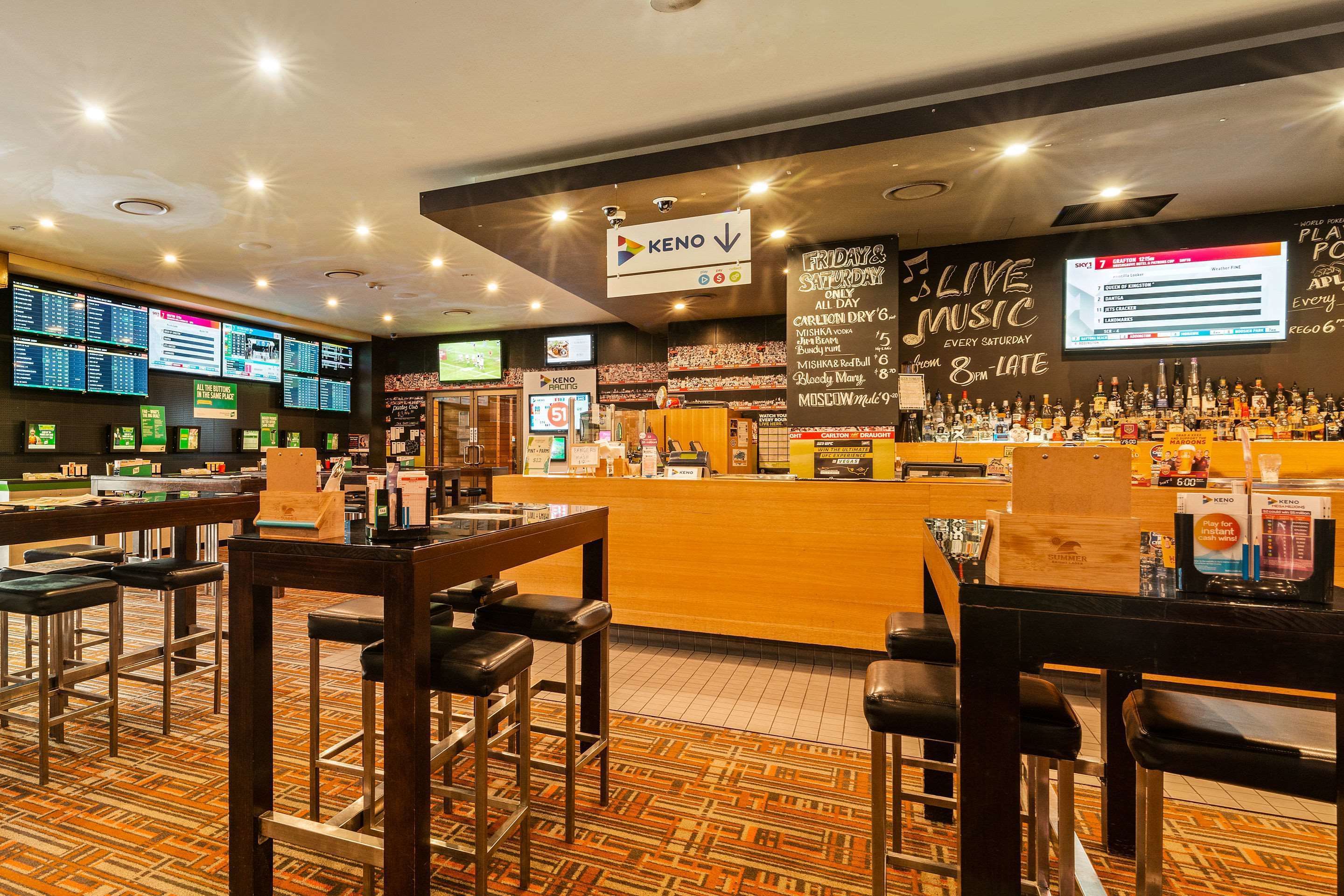 Angolo bar con un bancone, sgabelli e una lavagna dei menu.