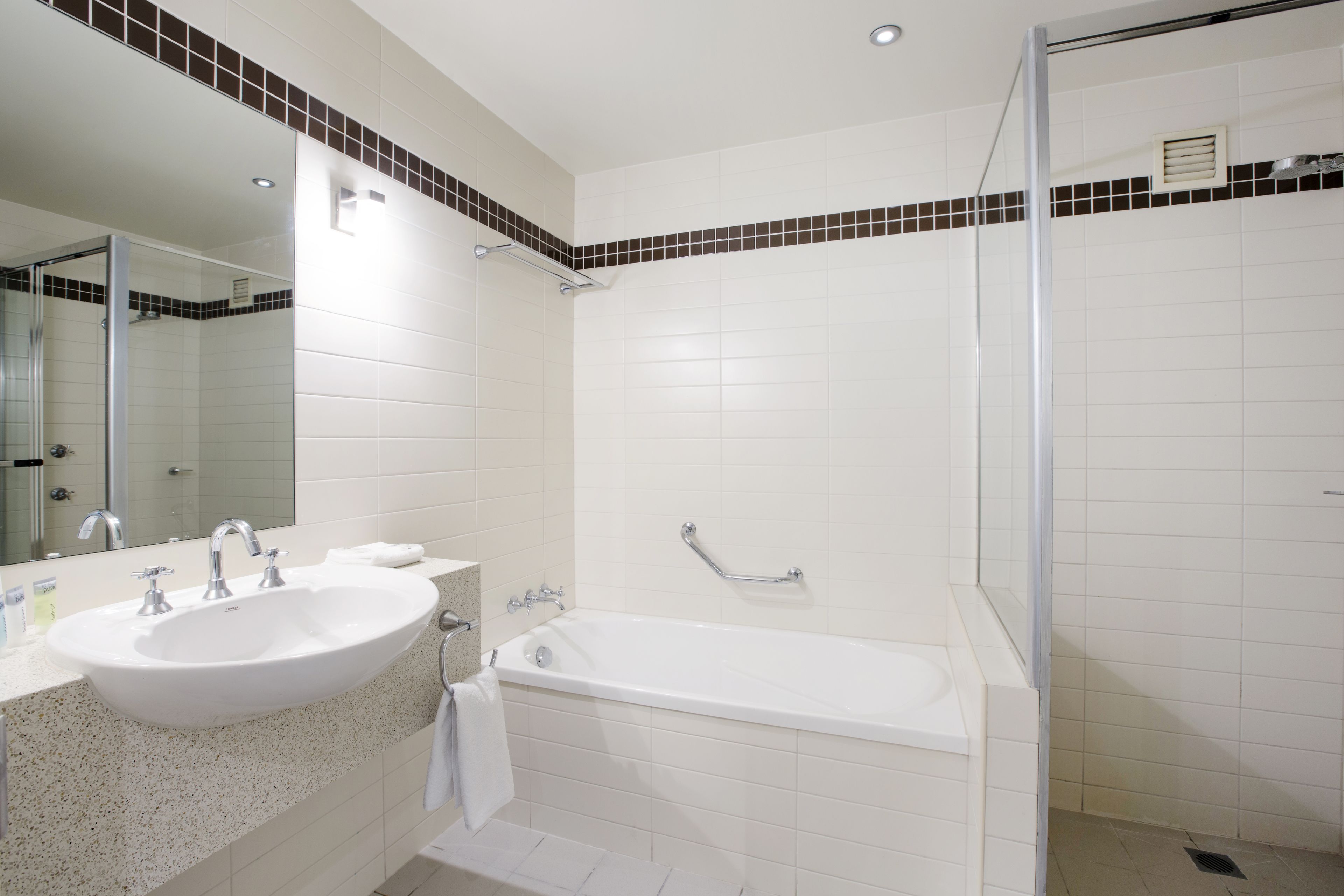 Une salle de bain moderne avec un lavabo, un miroir et une baignoire.