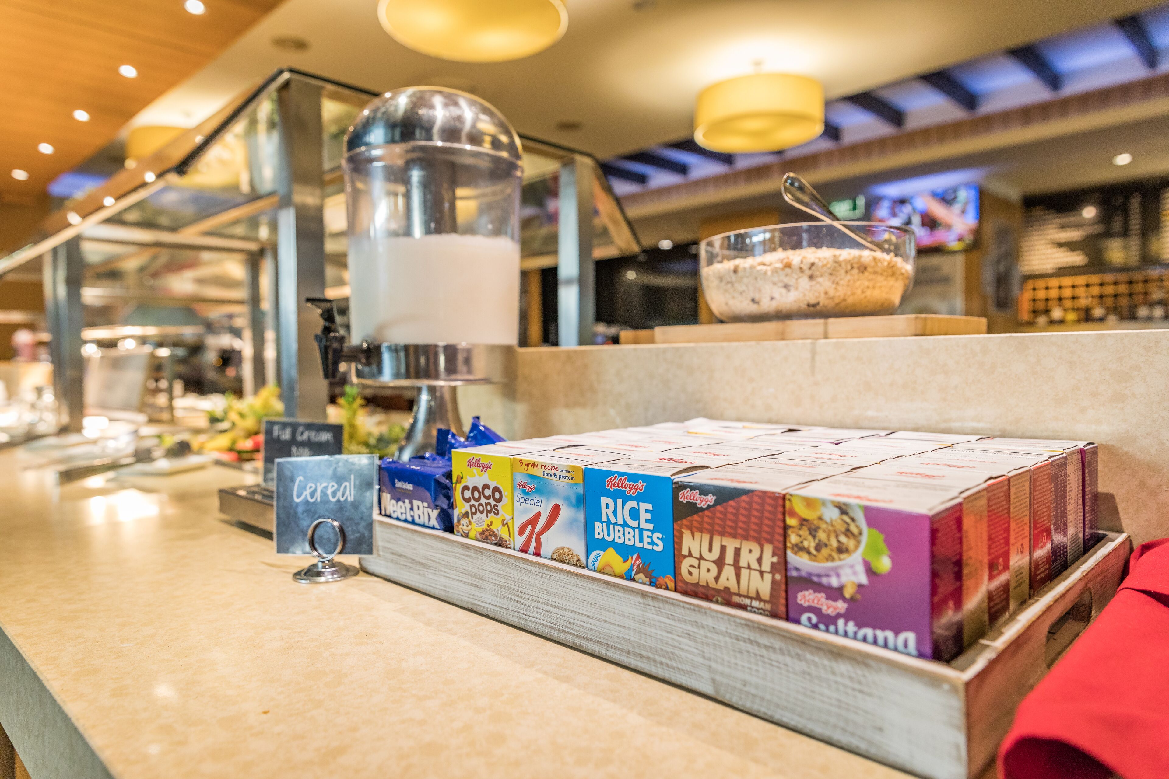 Un bufé de desayuno con cereales, arroz inflado y otros productos para el desayuno.