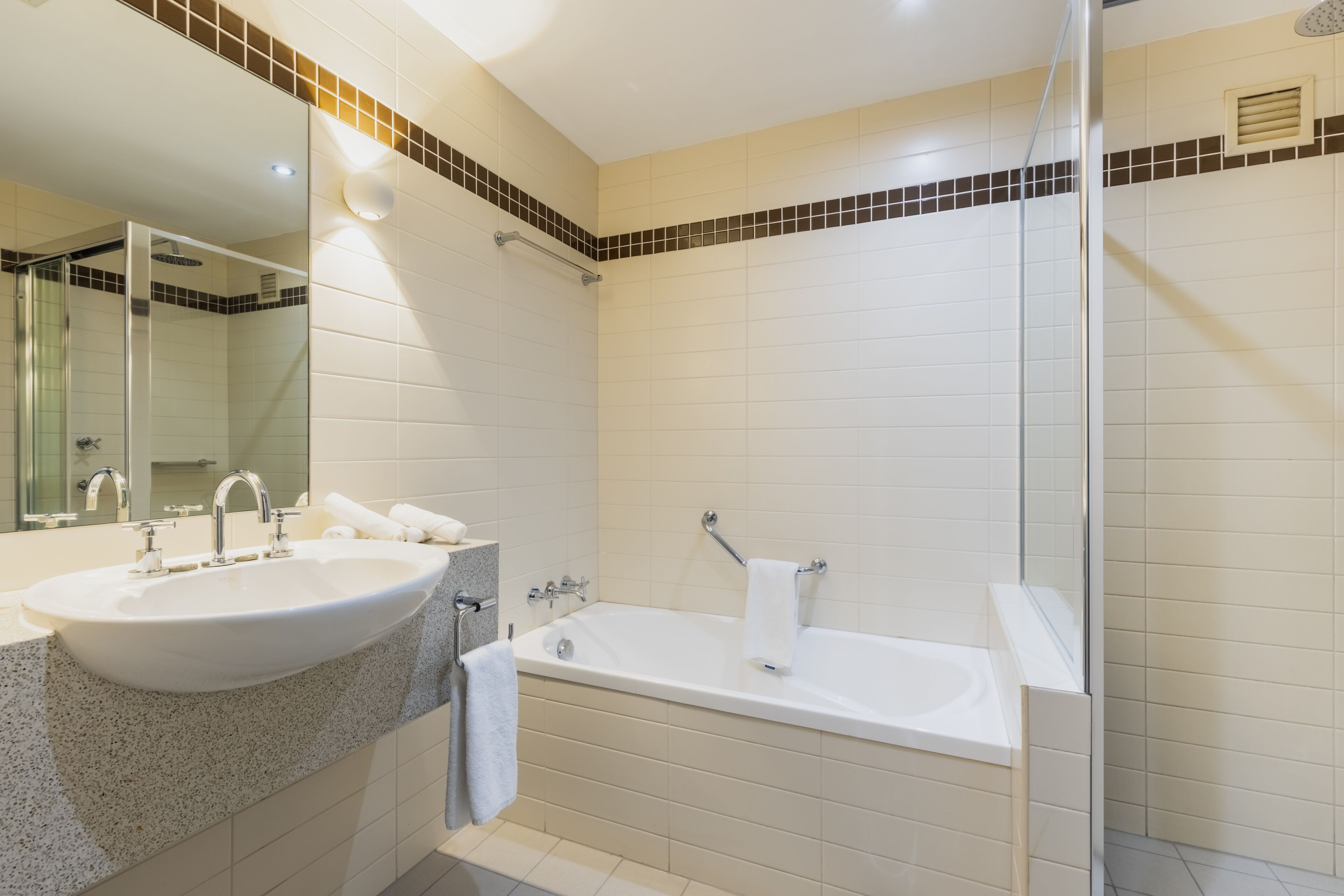 A modern bathroom with a large sink, a bathtub, and a shower area.
