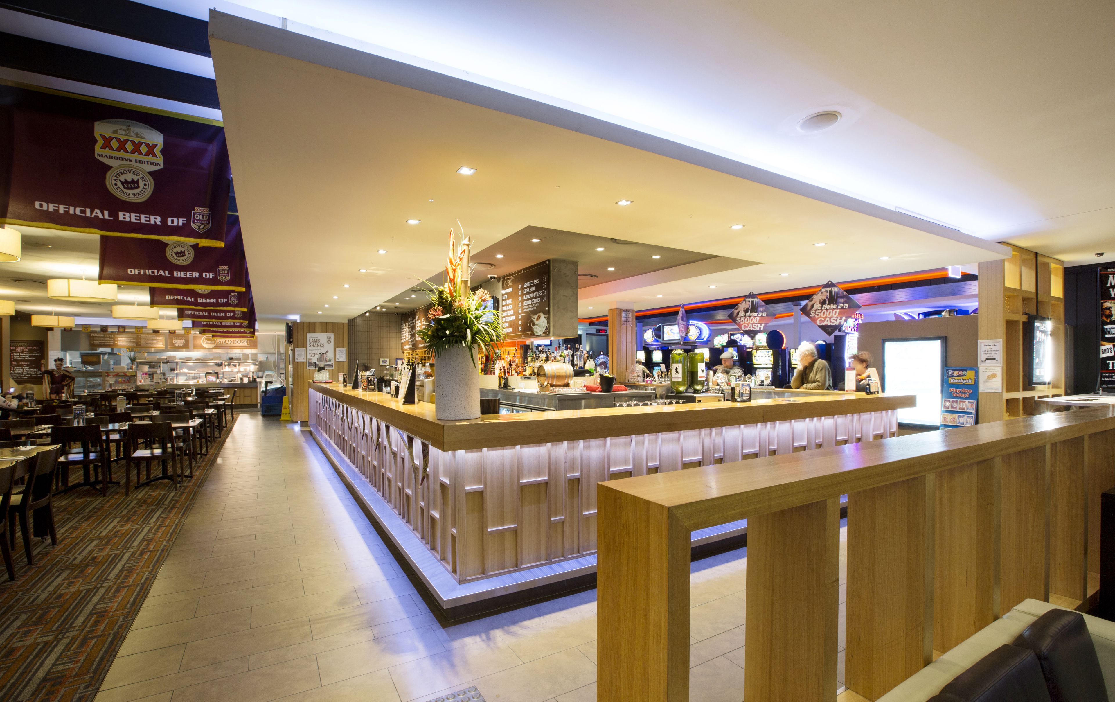 A modern bar area with a counter, seating, and a menu board.