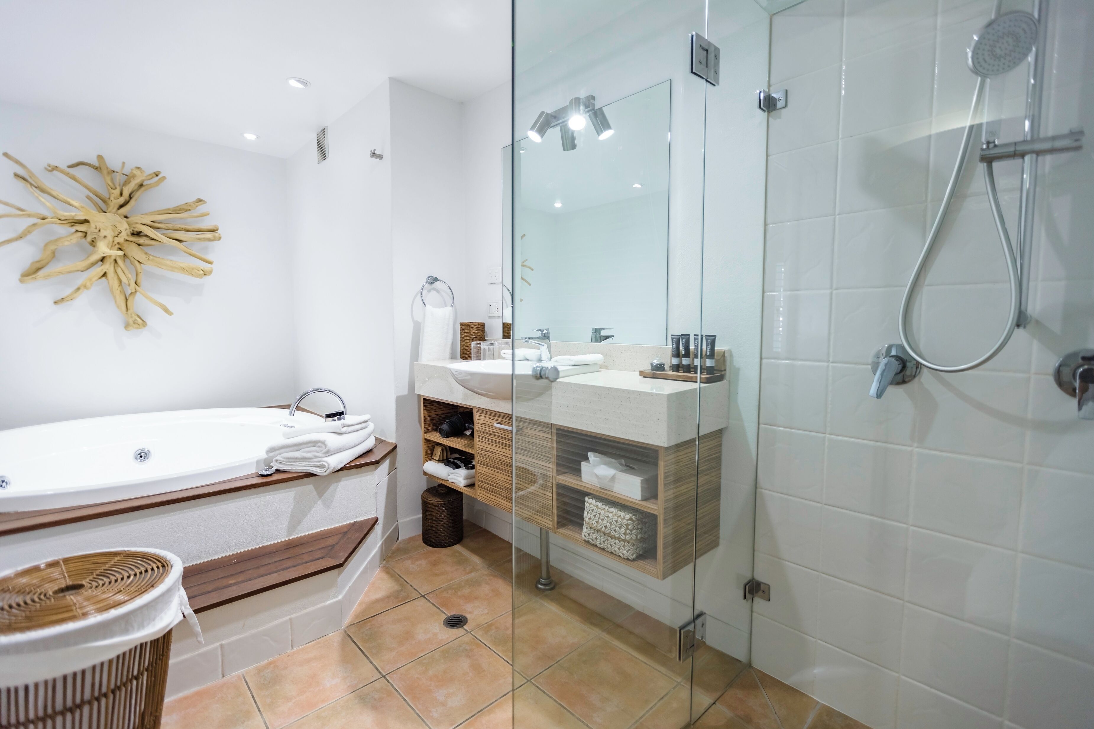 Une salle de bain moderne dotée d’une douche à parois de verre, d’une baignoire sur pieds et d’un meuble-lavabo avec un miroir.