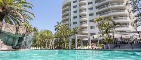 Una piscina al aire libre, sillones reclinables de piscina