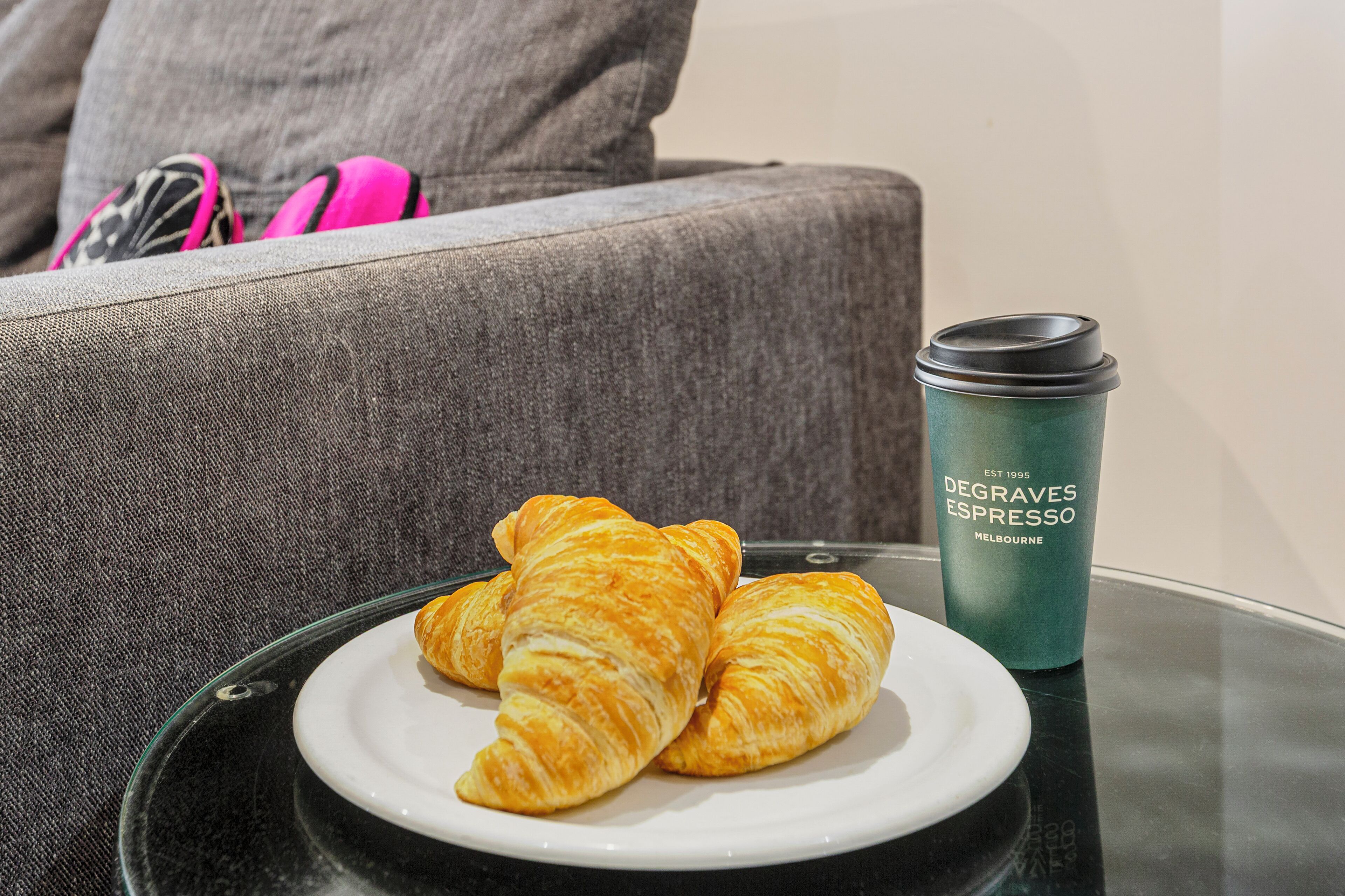 A plate with croissants and a Degraves Espresso cup on a table.