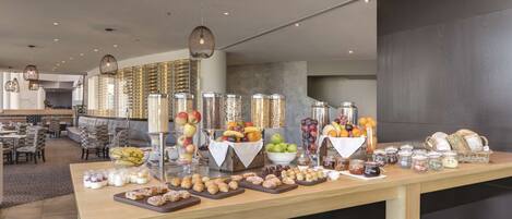 A buffet setup with various food items and condiments.