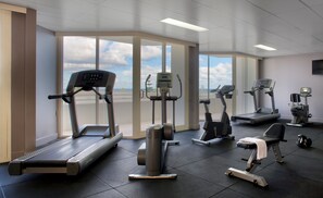 A gym with treadmills, elliptical machines, and stationary bikes.