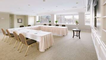A conference room with a long table, chairs, and potted plants.