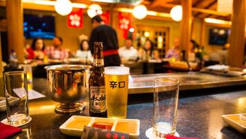 A bar area with a beer bottle, glasses, and a menu.