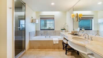 A modern bathroom with a glass-enclosed shower, a freestanding bathtub, and a double sink vanity.