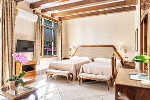 A hotel room with two beds, a TV, a desk, and a window with curtains. - Hotel Martino Spa and Resort (La Garita)