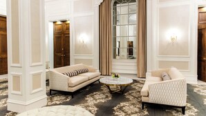 A luxurious room with a large window, two sofas, a round coffee table, and a patterned carpet. - The Lord Nelson Hotel & Suites (Halifax)