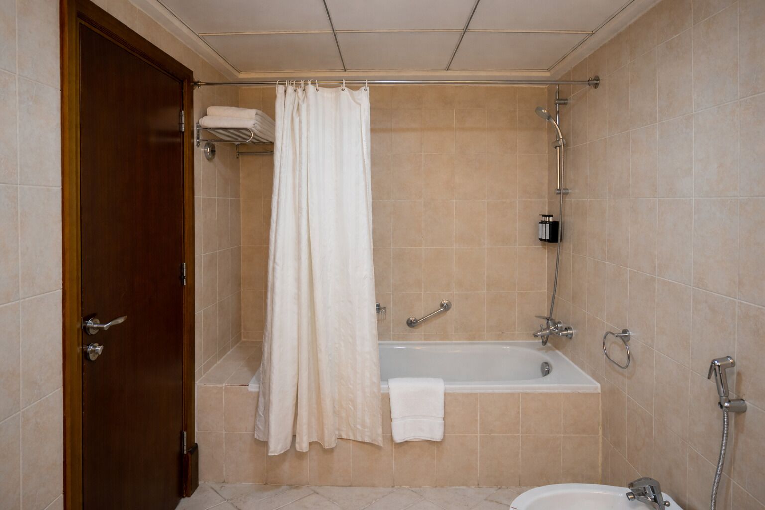 A bathroom with a bathtub, shower, and toilet.