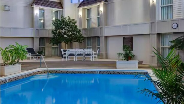 A pool area with a seating arrangement and potted plants.