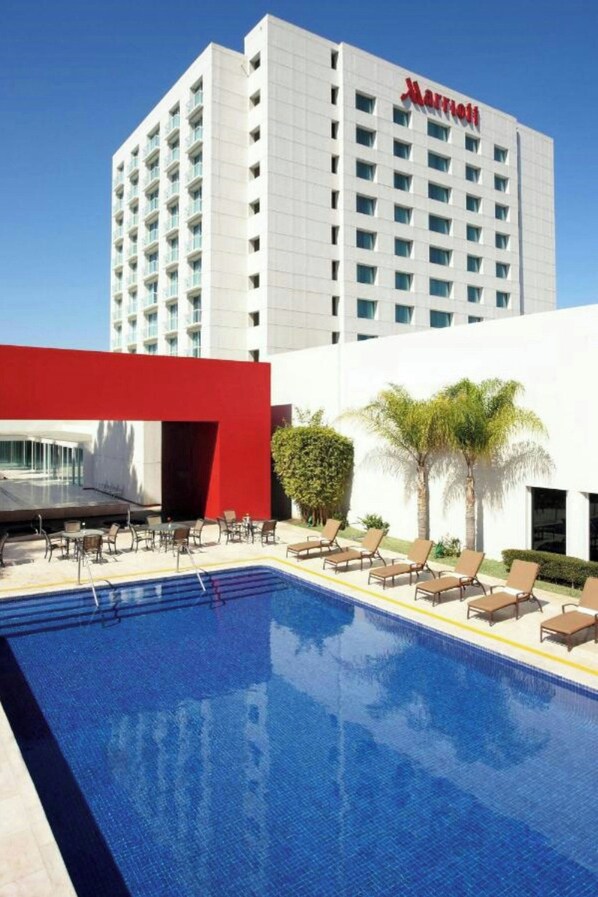 A Marriott hotel with a swimming pool, lounge chairs, and palm trees. - Marriott Hotel Tijuana (Tijuana)