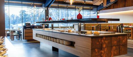 A modern kitchen with a central island, wooden cabinets, and a large window providing a view of the outdoors.