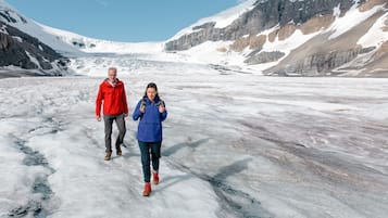 Een gletsjer, met twee mensen die aan het wandelen zijn.