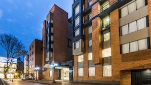 A multi-story building with a brick facade, large windows, and a visible entrance. - GHL Hotel Hamilton (Bogotá)