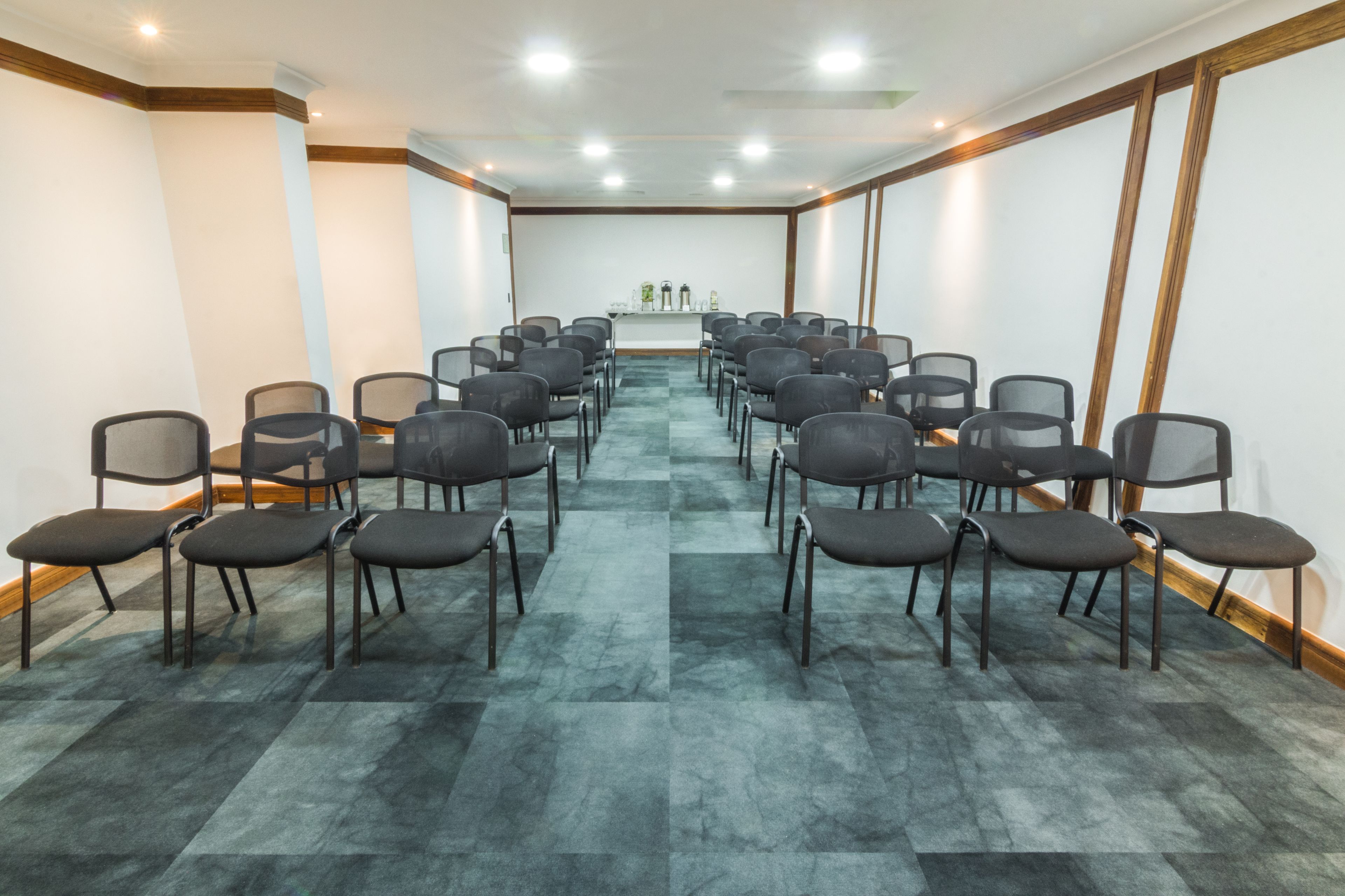 A conference room with rows of chairs facing a podium.