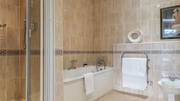 A modern bathroom with a glass-enclosed shower, a bathtub, a sink, and a toilet.