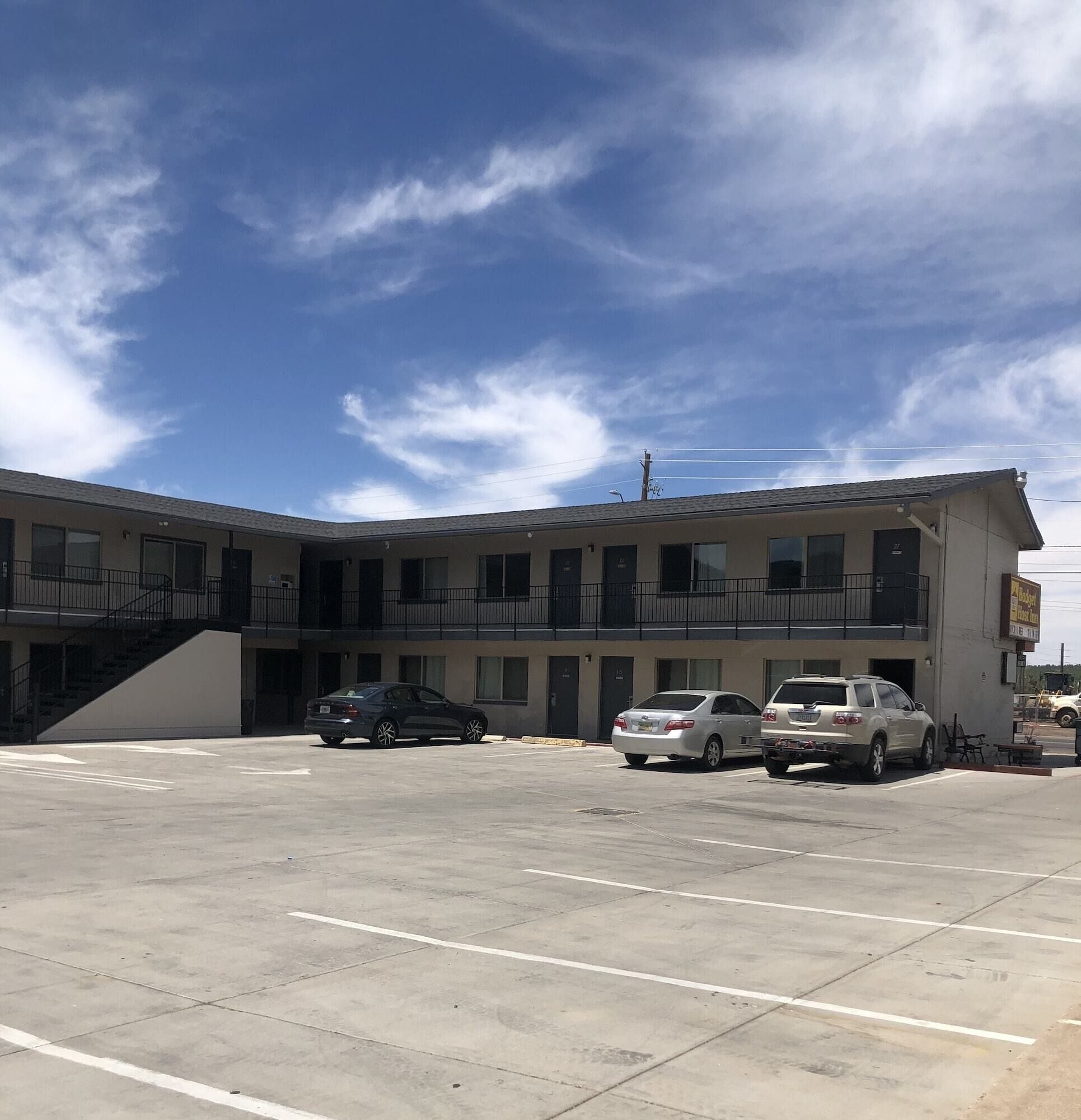 A multi-story building with a parking lot in front.
