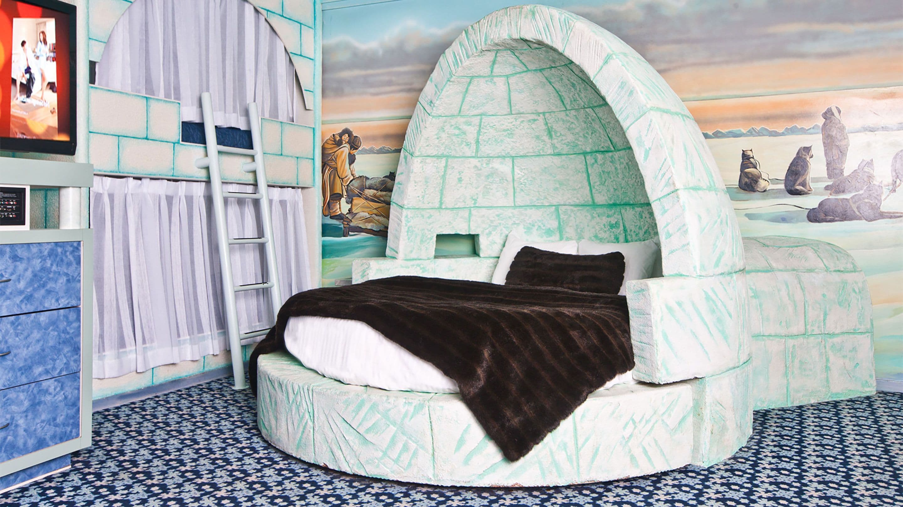 A circular bed with a dome-shaped canopy, a ladder, and a mural of a landscape with mountains and animals.