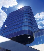 A modern high-rise building with a curved facade and large windows.