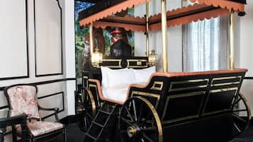 A four-poster bed with a canopy, a chair, and a mirror reflecting a person.