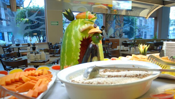Un buffet proposant une variété de plats et agrémenté d’une grande pièce maîtresse décorative en forme de dragon.
