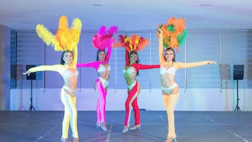 A dance performance in a spacious indoor venue with a stage and professional lighting equipment.