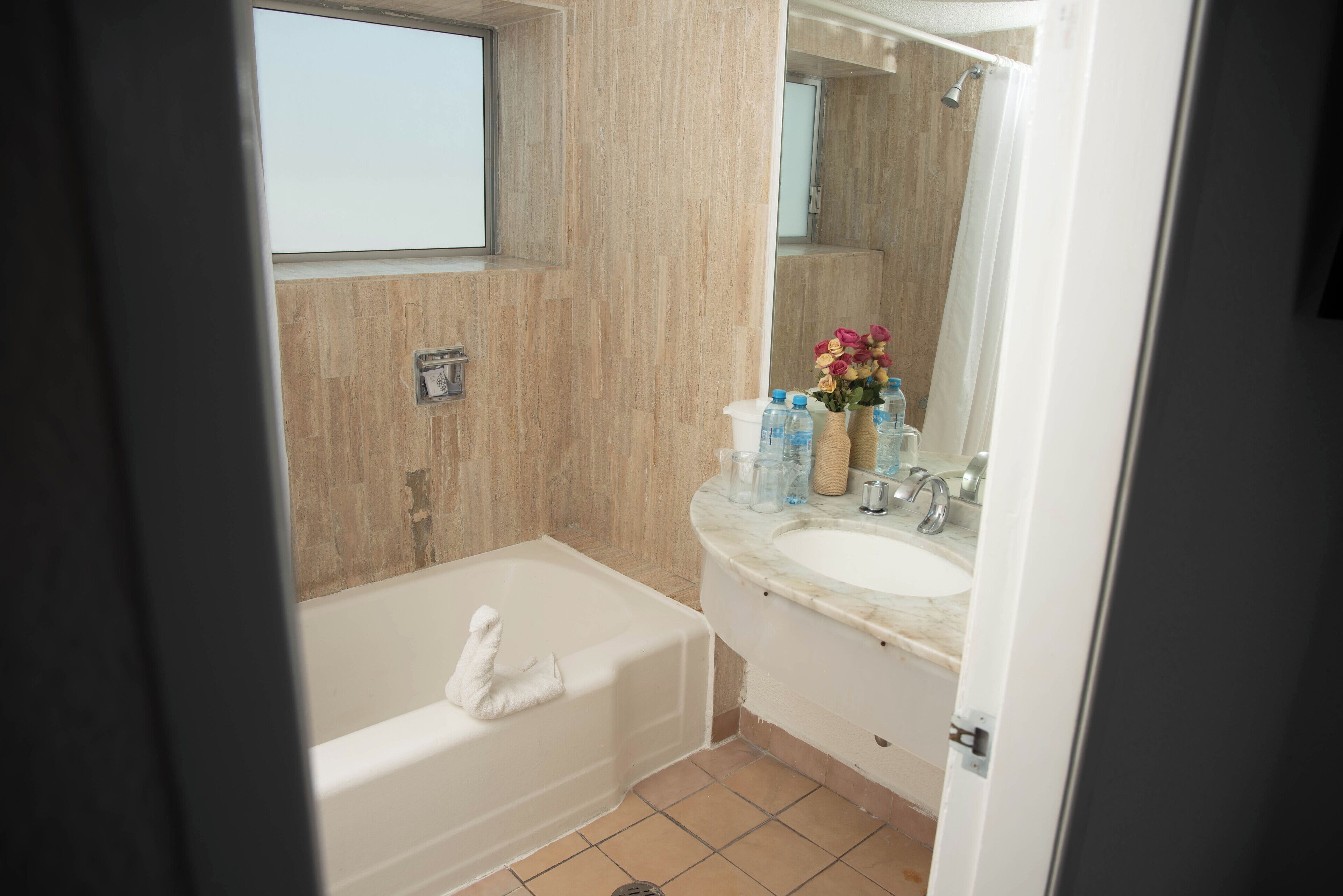 A bathroom with a bathtub, a sink, and a mirror.