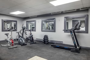 A gym with exercise equipment, mirrors, and a patterned floor. - Days Inn & Suites by Wyndham Summerside (Summerside)