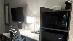 A modern office space with a desk, ergonomic chair, flat-screen TV, desk lamp, microwave, and refrigerator. - Days Inn & Suites by Wyndham Summerside (Summerside)