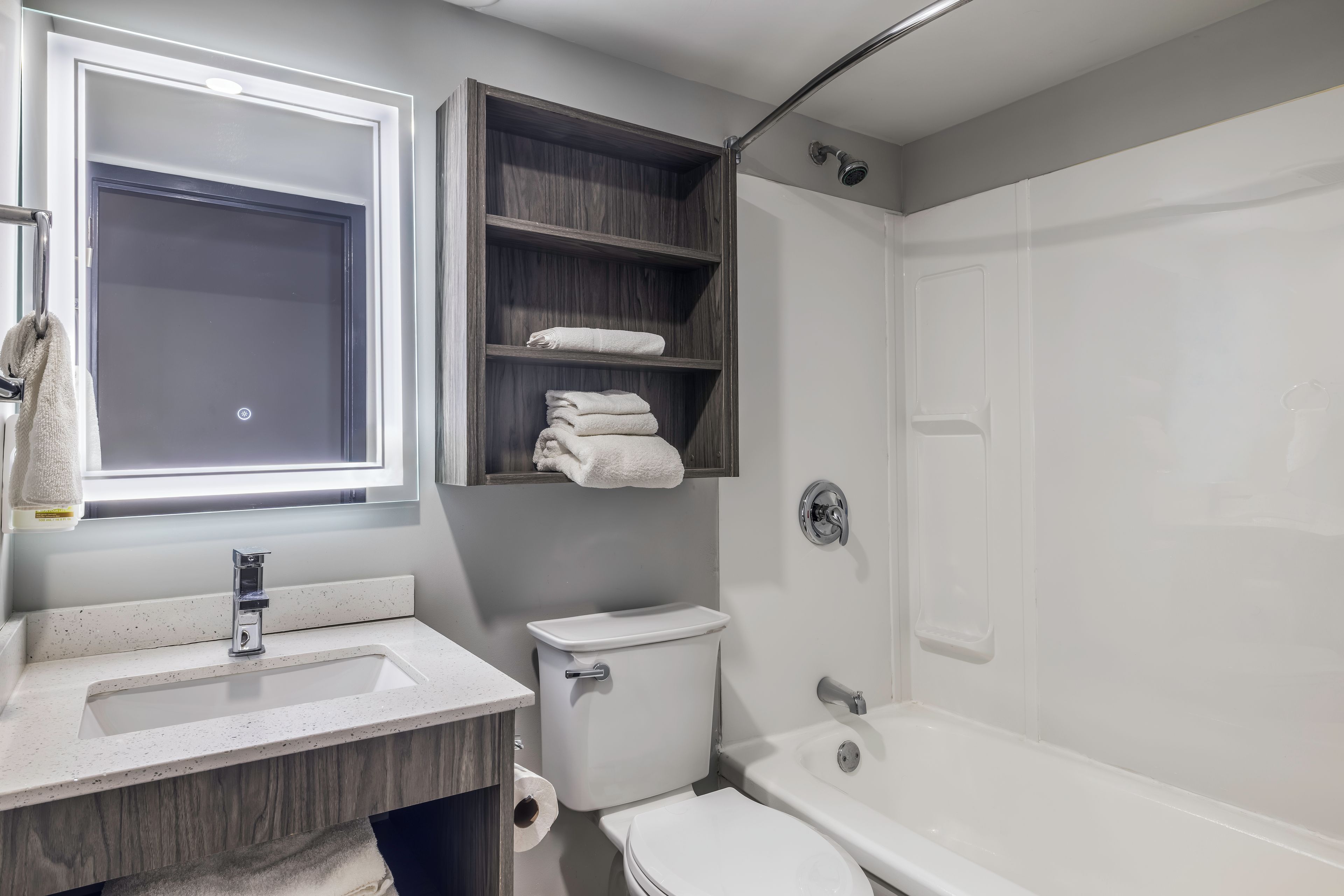 Un baño con lavamanos blanco, inodoro, bañera y zona de ducha.