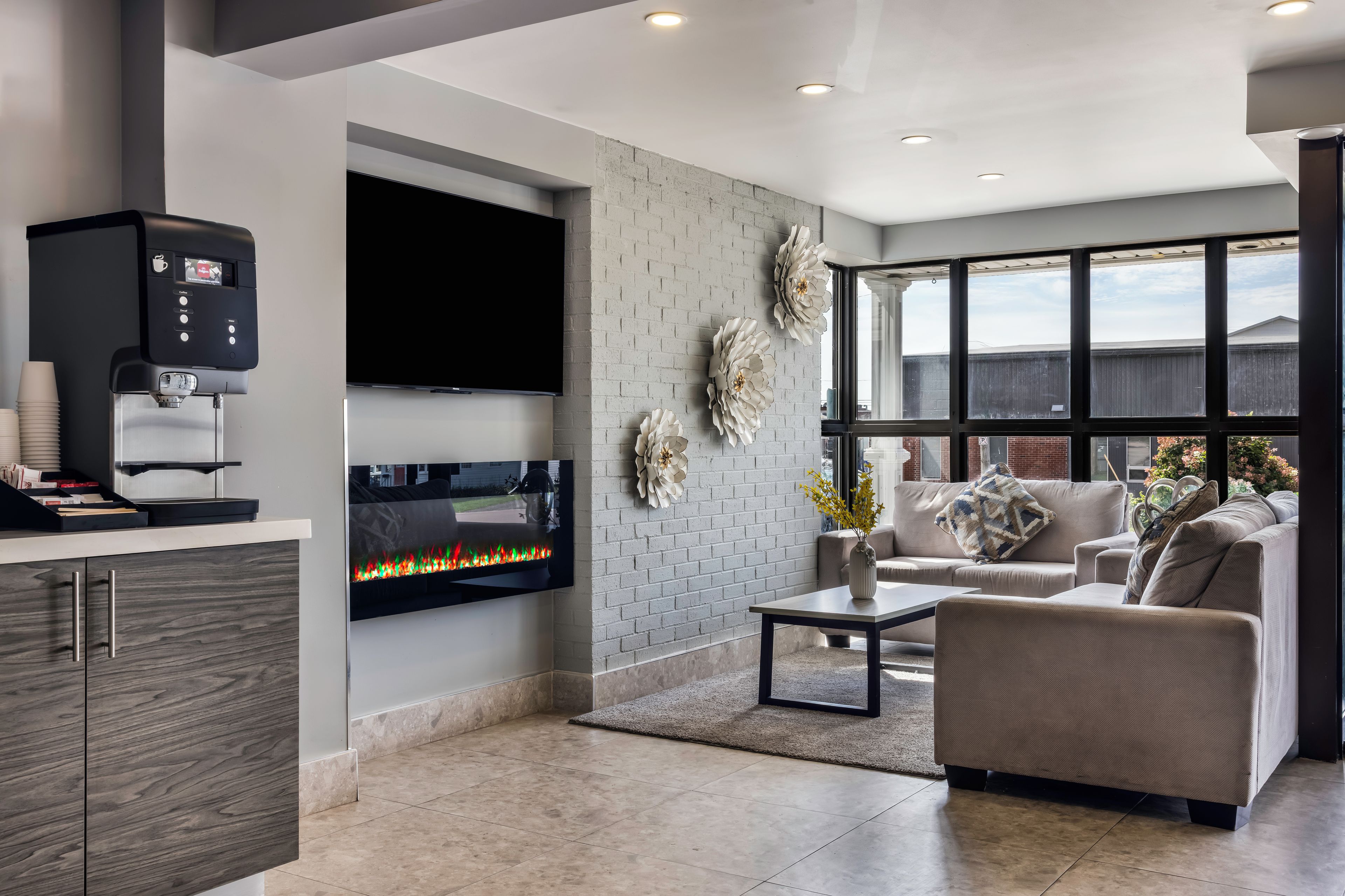 Una sala de estar moderna con un televisor de pantalla plana, una cafetera y una chimenea.